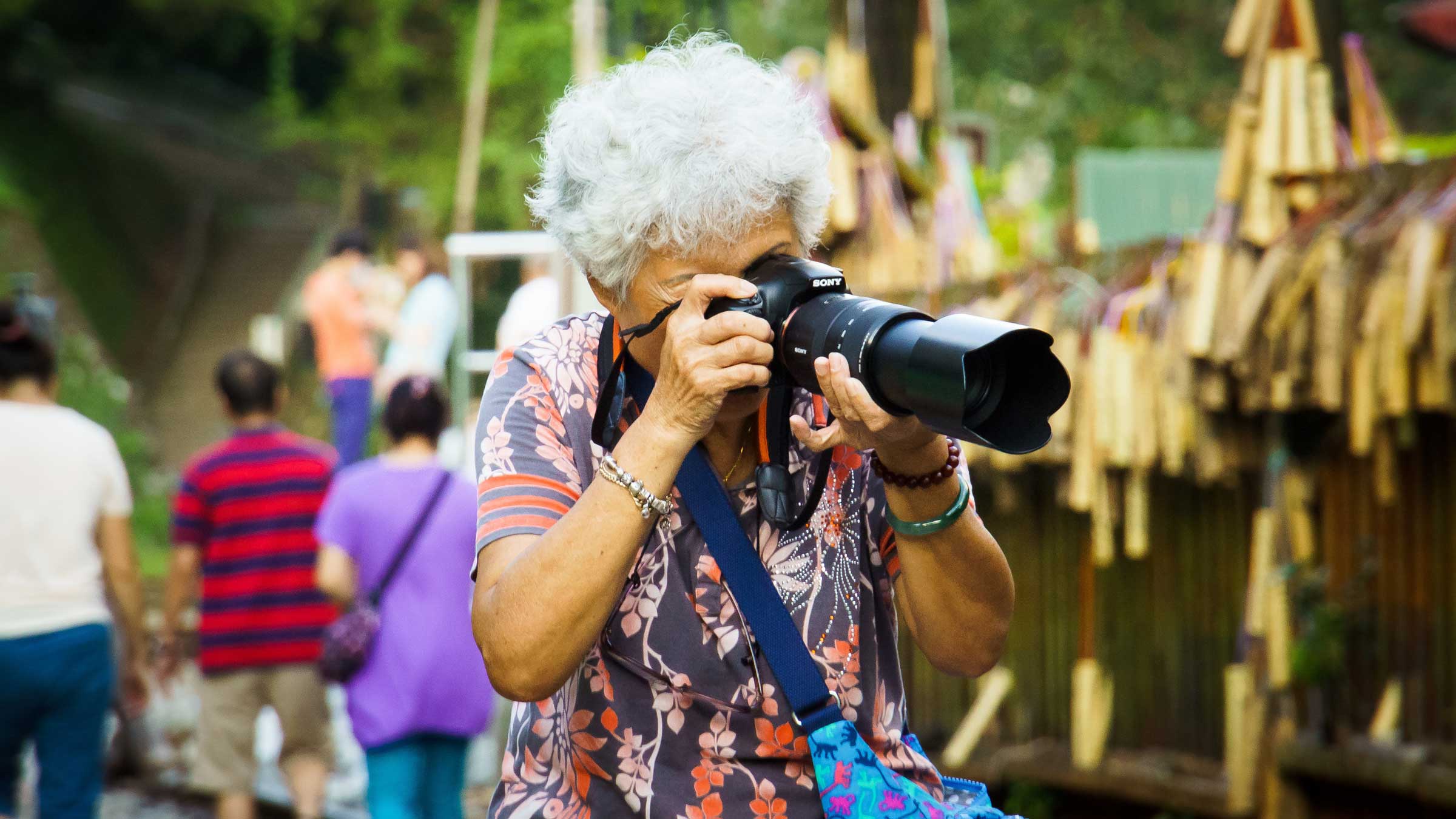 Anziana in vacanza che scatta delle foto